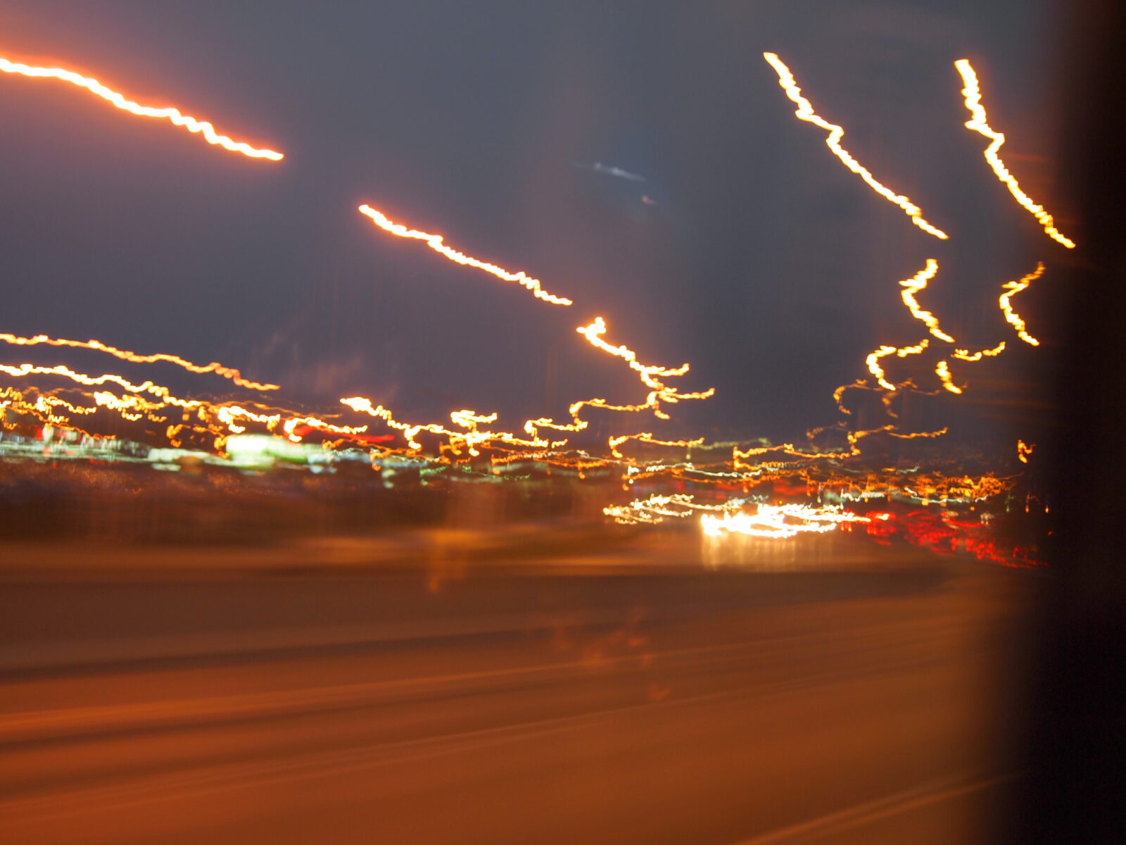 La imagen muestra luces distorsionadas por un vehículo en movimiento